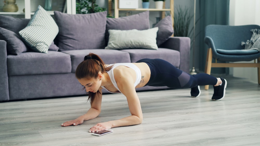 Woman doing push-ups on the floor as a bodyweight strength exercise at home